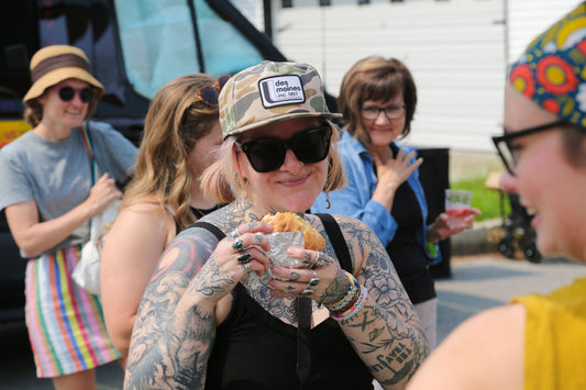 Jamie Nicolino, owner of The Collective, eating a New World Kitchen sandwich at the Northside Market in Des Moines, Iowa