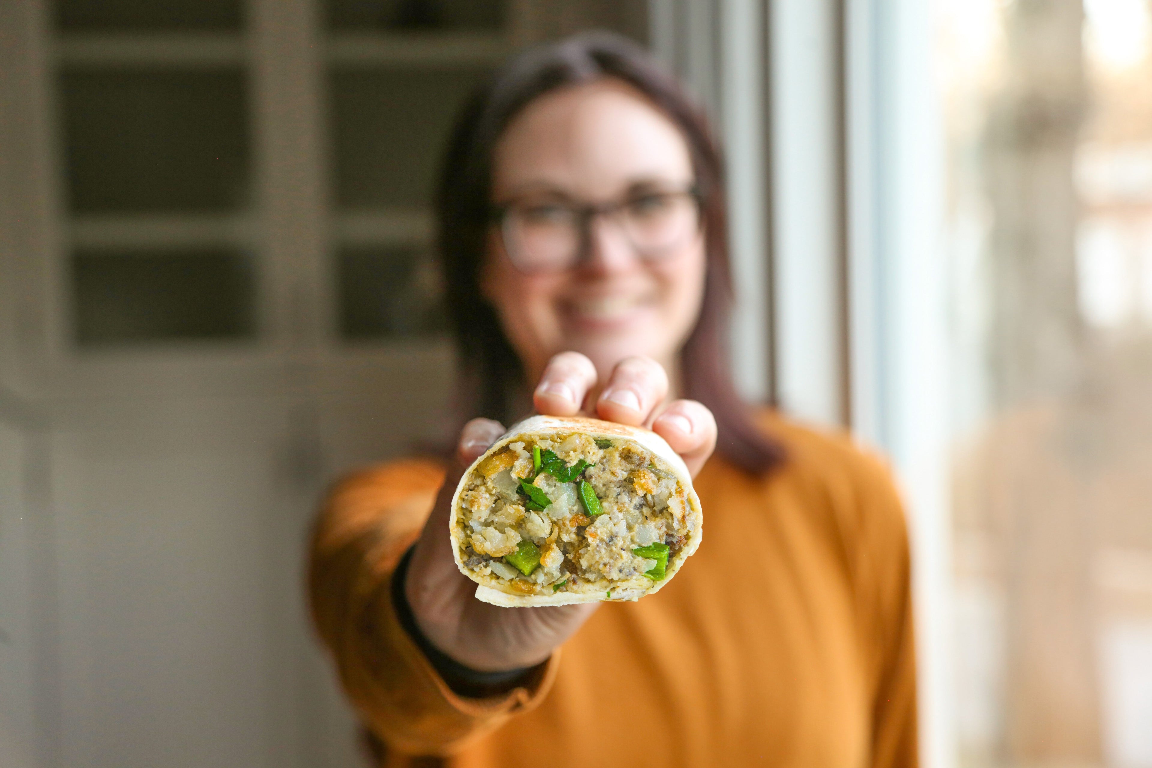 Chef Madeline Krantz holds a vegan burrito she made